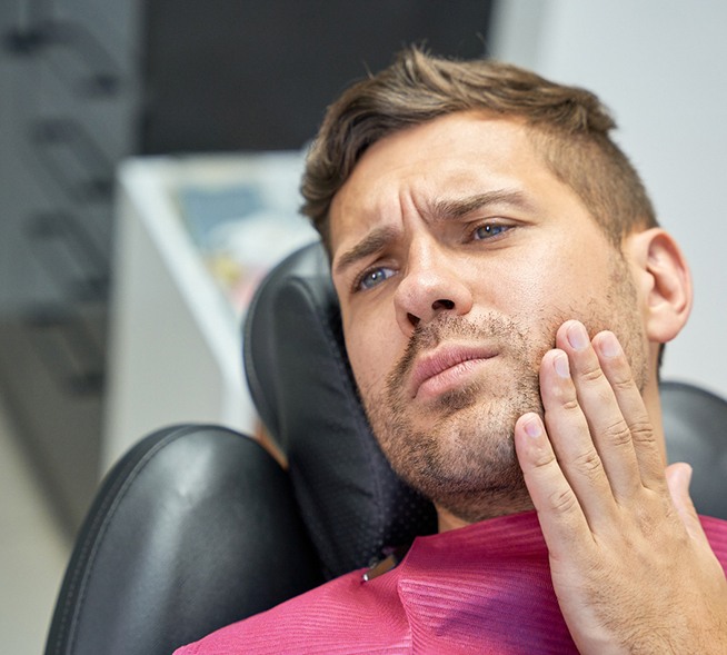 Patient with toothache sitting in treatment chair