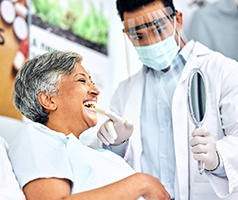Patient smiling at reflection in small mirror