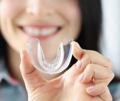 Dental implant patient in Mt. Dora showing off mouthguard