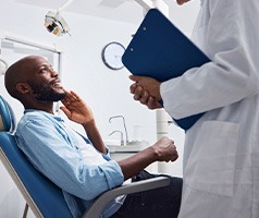 Man with toothache taking to dentist holding clipboard