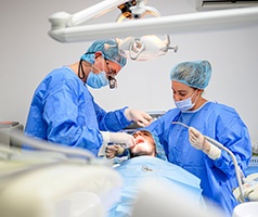 an oral surgeon performing dental implant placement surgery