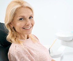 a patient smiling after receiving her dental implant restorations