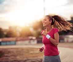 Closeup of smiling woman running outside