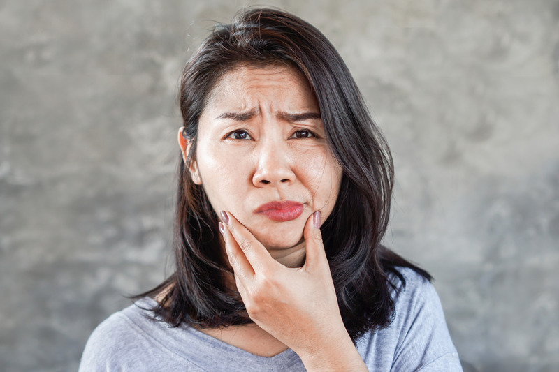 Patient holding their cheeks due to dental emergencies